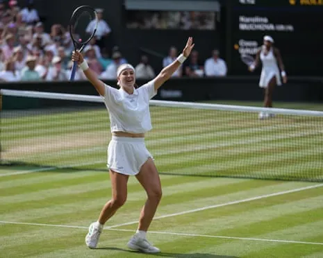Karolina Muchova celebrates with arms raised on a grass court at Wimbledon.
