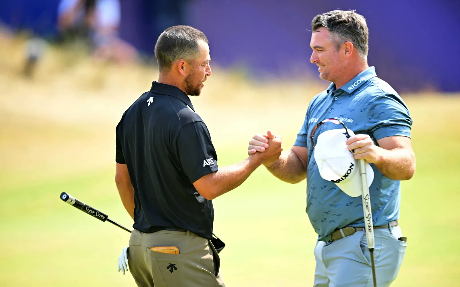 New Zealand's Ryan Fox (R) is congratulated by US golfer Xander Schauffele (L) after returning a record Open Championship low score equaling 62, on the 18th green on day three of the 154th Open Golf championship at Royal Birkdale Golf Club near Southport in north-west England on July 18, 2026. (Photo by ANDY BUCHANAN / AFP) / RESTRICTED TO EDITORIAL USE